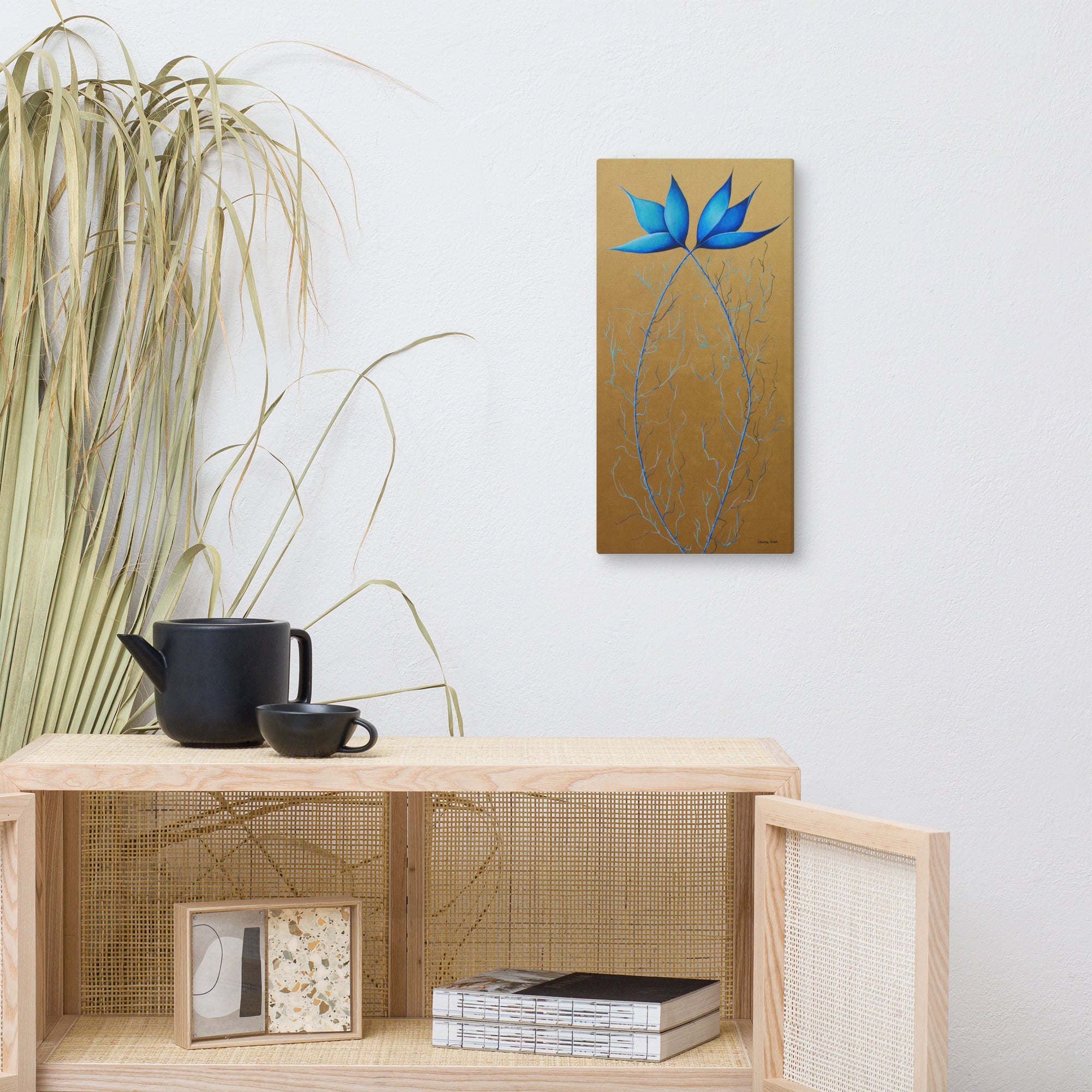 Decorative wall art with blue flower on gold background above a wooden shelf with decor items. Abstract botanical acrylic painting, colourful contemporary wall art